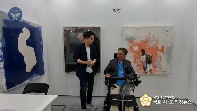 사진=박정 작가(우)가 장인보 감독에게 작품에 대해 설명하고 있다